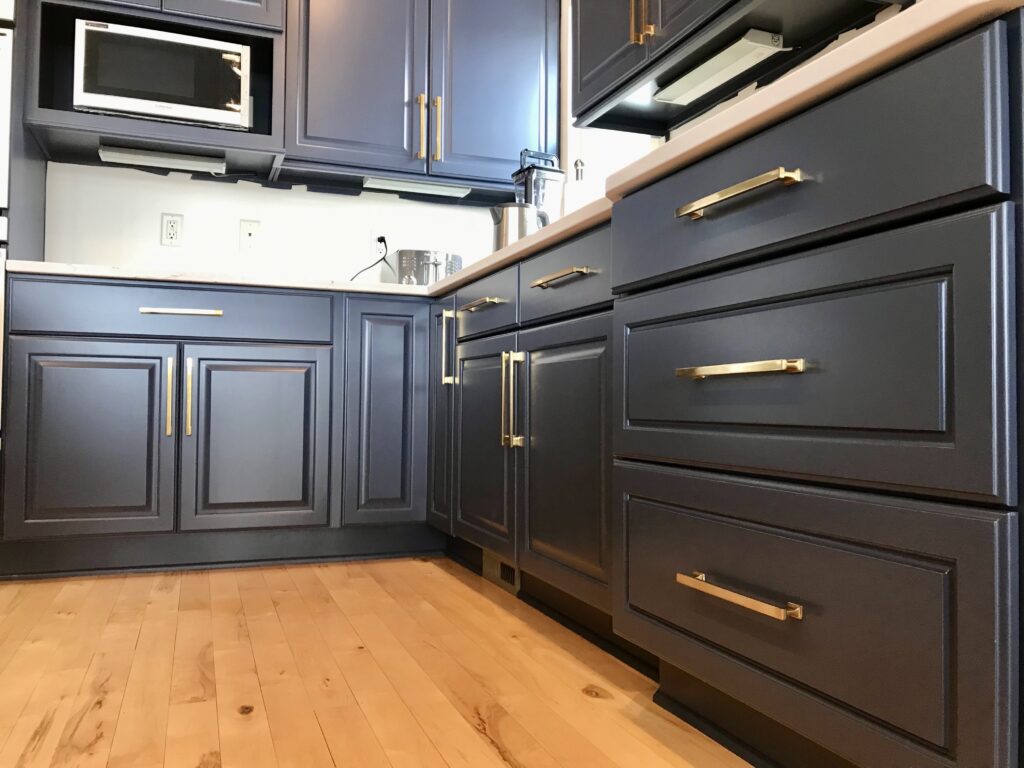 Cabinets refinished by Craine Painting in navy blue with brass hardware.