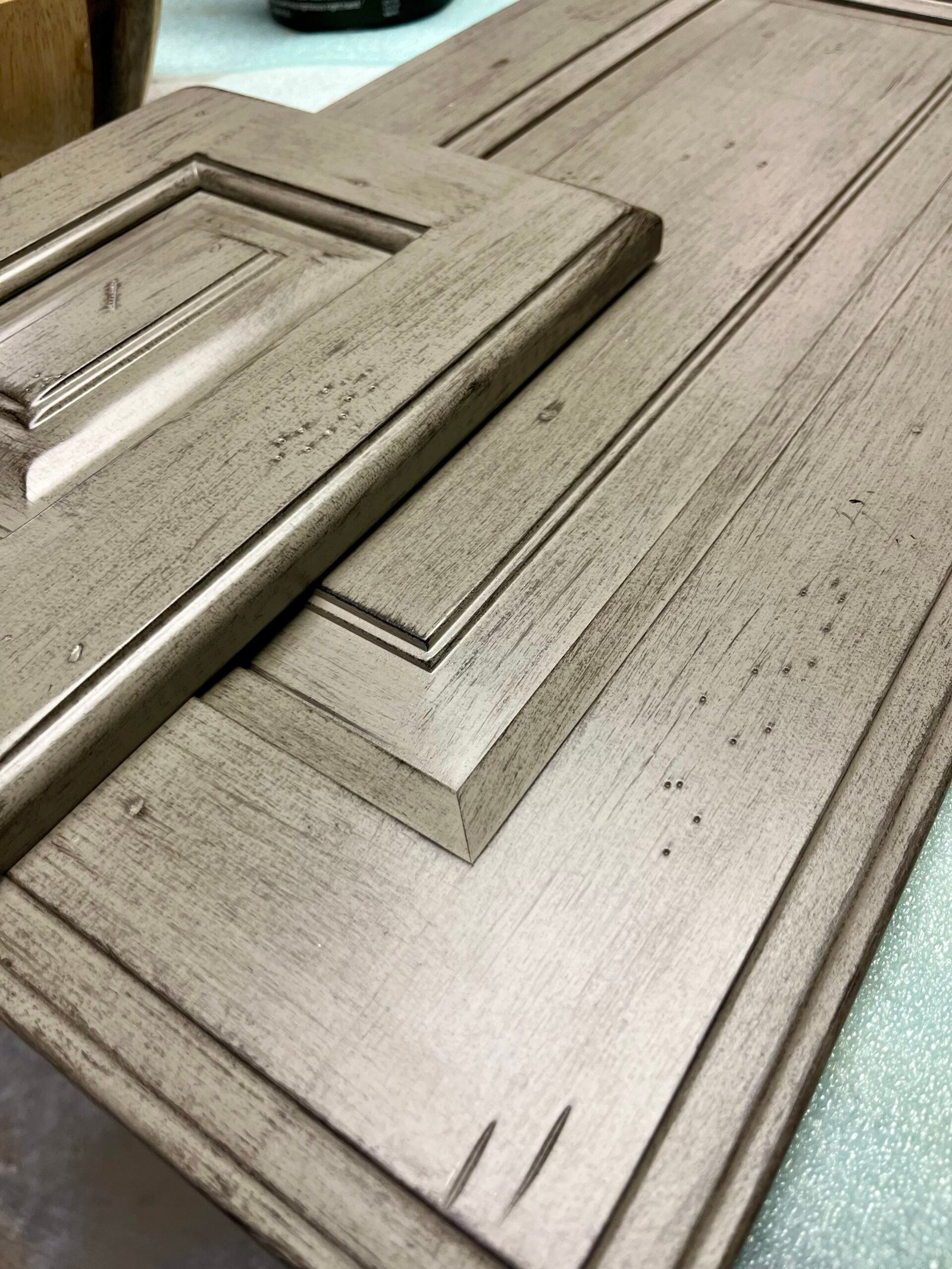Green distressed & glazed cabinet doors, finish matched by Craine Painting