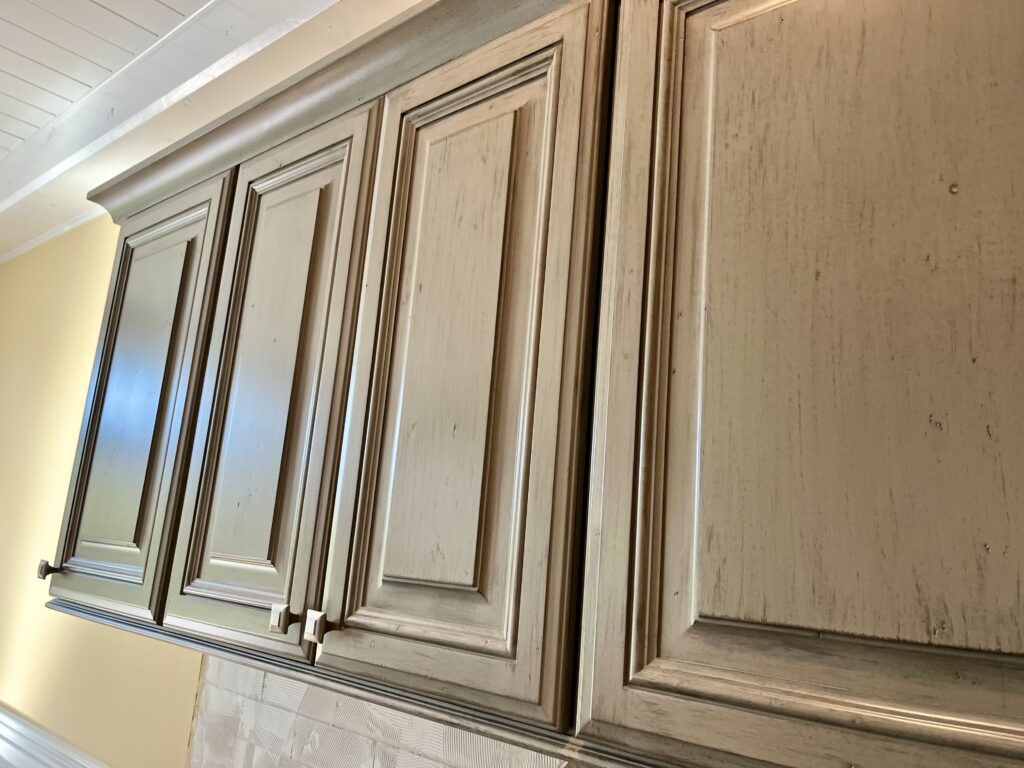 Green distressed and glazed cabinet doors, refinished by Michael Craine
