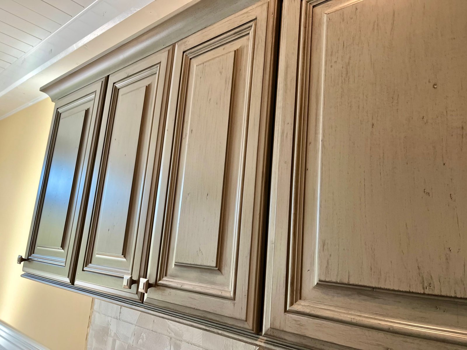 Green distressed and glazed cabinet doors, refinished by Michael Craine