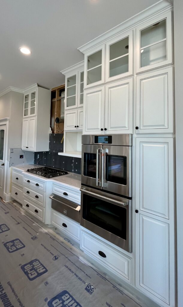 Refinished white cabinet doors, pinstriped with a gray glaze. 